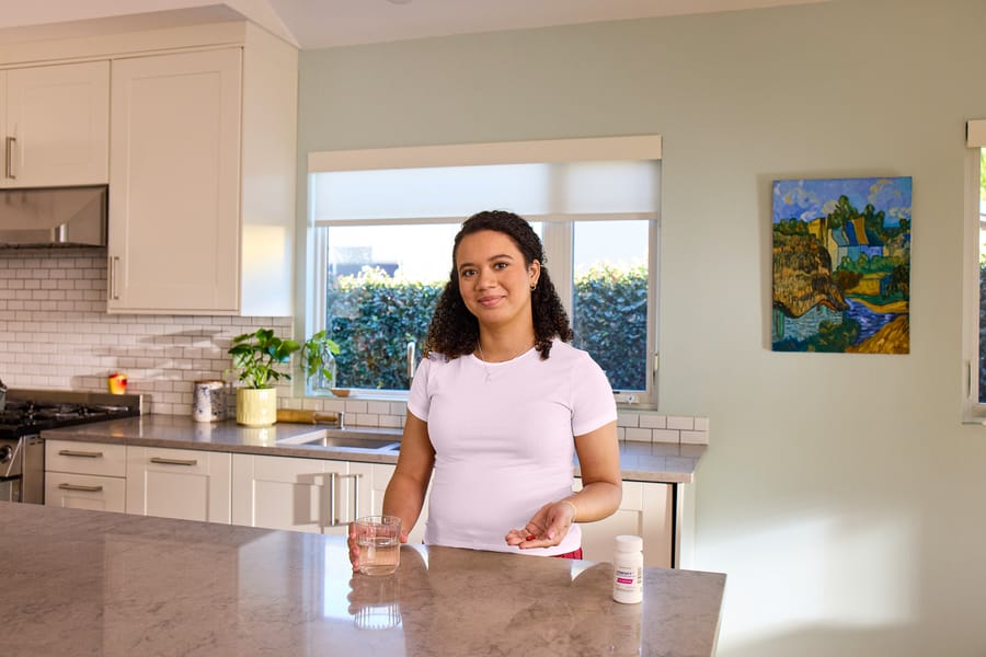 C Chanel, an actual COBENFY (xanomeline and trospium chloride) patient,  in their kitchen about to take their daily COBENFY (xanomeline and  trospium chloride) dose.