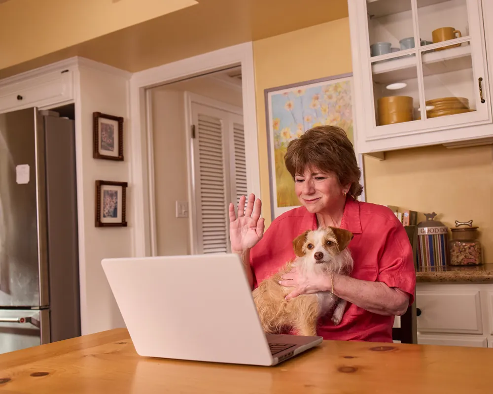 Sheryl, an actual COBENFY (xanomeline and trospium chloride) patient,  on a video call with a COBENFY Champion in her kitchen